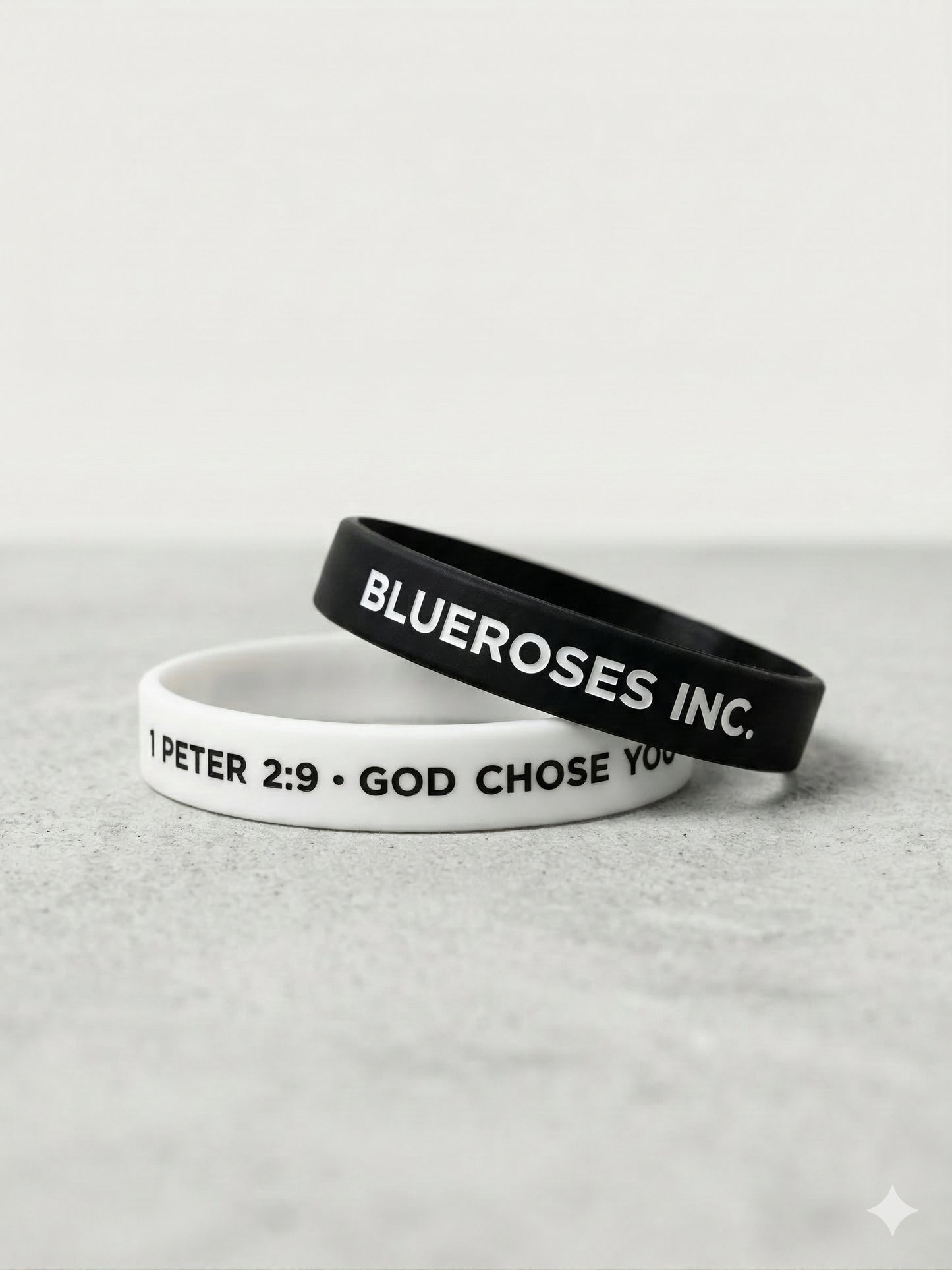 Two wristbands, one white and one black, with text on a light gray background.